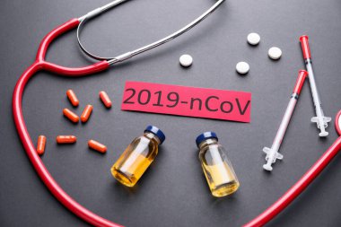 Stethoscope and medicines for Coronavirus on dark background