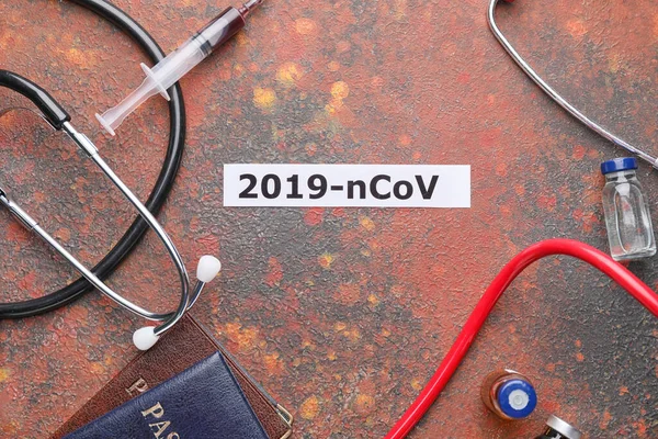 Passports with stethoscopes and vaccine for Coronavirus on color background