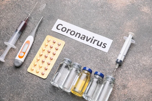 Termometr z lekami na Coronavirus na szarym tle — Zdjęcie stockowe
