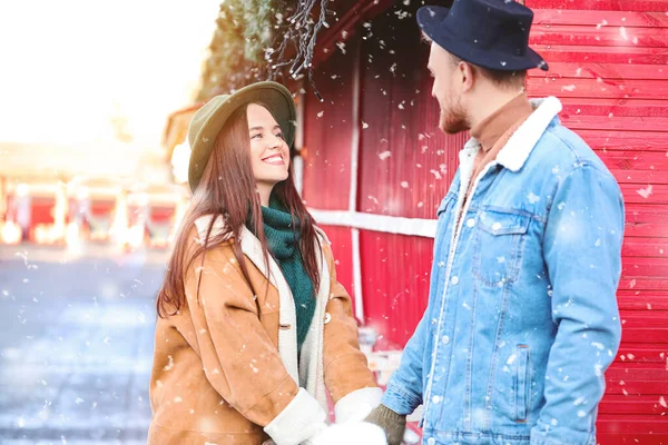 Happy young couple on Christmas fair outdoors — Stock Photo, Image