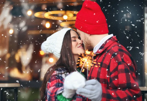 冬の日に屋外でクリスマスの輝きを持つ幸せな若いカップル — ストック写真