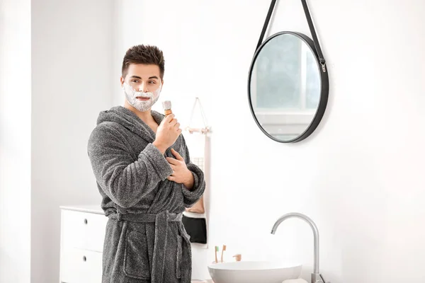 Handsome young man shaving in bathroom — Stock Photo, Image