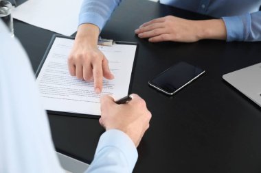 Banka müdürü ofiste bir adamla çalışıyor.