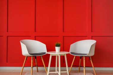 Rahat sandalyeler ve renkli duvarın yanındaki masa