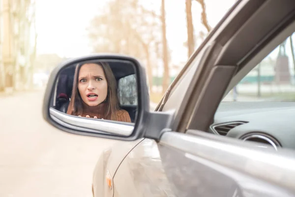 Az aggódó járművezető tükröződése az autó oldalsó tükrében — Stock Fotó