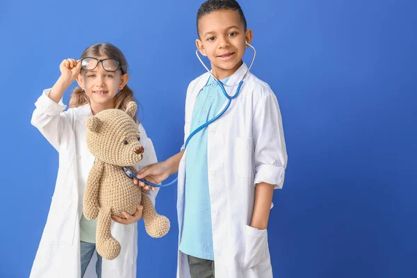 Bonitos pequenos médicos em fundo de cor — Fotografia de Stock