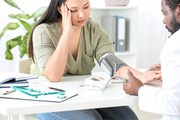 Cardiologista masculino examinando paciente feminina na clínica — Fotografia de Stock