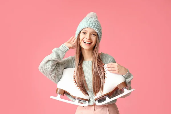 Beautiful young woman with ice skates on color background — 스톡 사진
