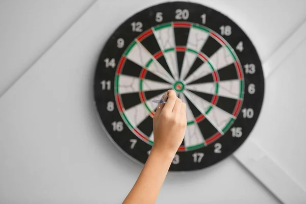 Ung kvinna spelar dart inomhus — Stockfoto