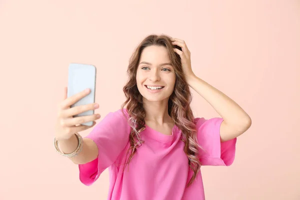 Mladá žena přičemž selfie na barevném pozadí — Stock fotografie