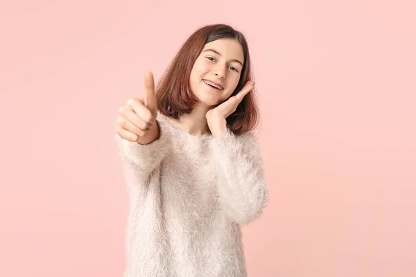 Tonårstjej med tandställning visar tummen upp gest på färg bakgrund — Stockfoto