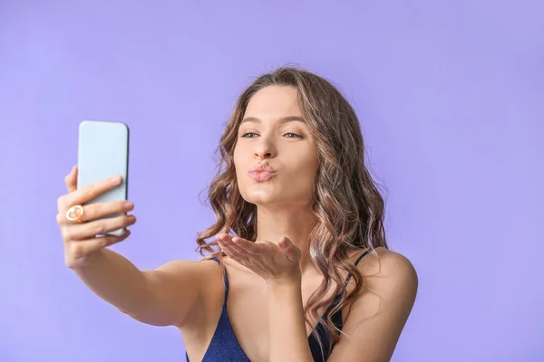 Jovem mulher tomando selfie no fundo de cor — Fotografia de Stock