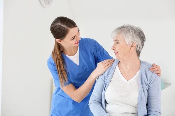 Medico femminile con donna anziana affetta da sindrome di Parkinson in clinica — Foto Stock