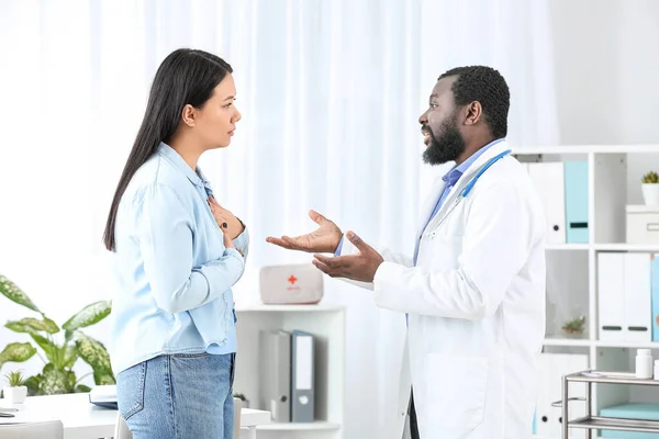 Jonge vrouw op bezoek bij mannelijke cardioloog in kliniek — Stockfoto