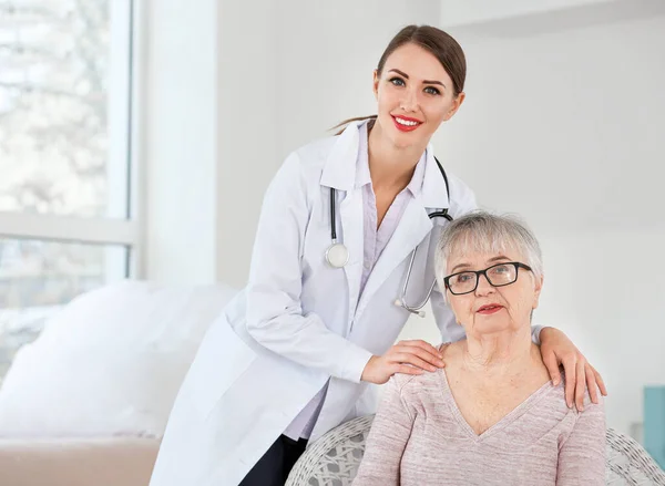 Female doctor with senior woman suffering from Parkinson syndrome in clinic — Stock Photo, Image