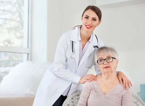 Doctora con mujer mayor que sufre de síndrome de Parkinson en la clínica — Foto de Stock