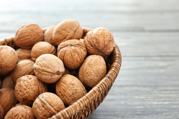 Basket with tasty walnuts on table — Stock Photo, Image