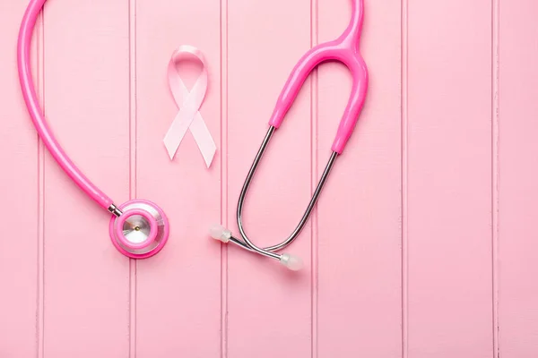 Cinta rosa con estetoscopio sobre fondo de madera blanca. Concepto de conciencia sobre el cáncer de mama — Foto de Stock