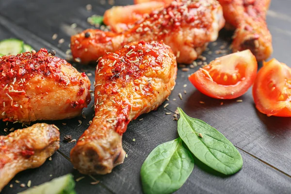 Cooked chicken drumsticks on dark wooden background