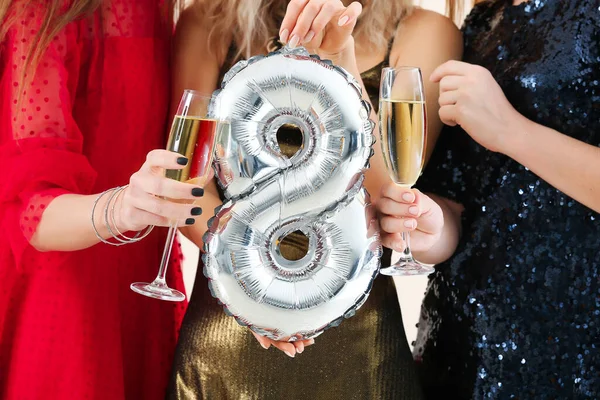 Beautiful young women with champagne and balloon in shape of figure 8. International Women's Day celebration — Stock Photo, Image