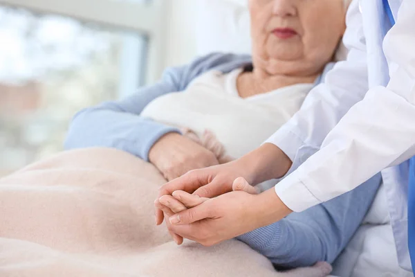 Doctora con mujer mayor que sufre de síndrome de Parkinson en la clínica — Foto de Stock