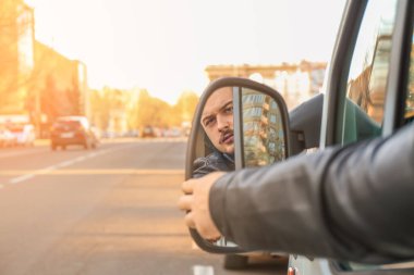 Sürücü, modern arabanın yan aynasını ayarlıyor