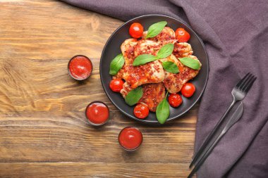 Ahşap arka planda soslu tavuk kanadı.