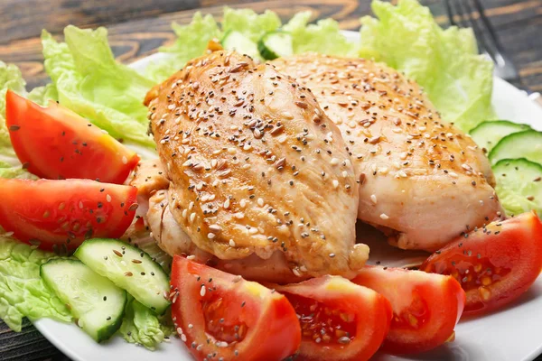 Cooked chicken fillet with vegetables on plate, closeup