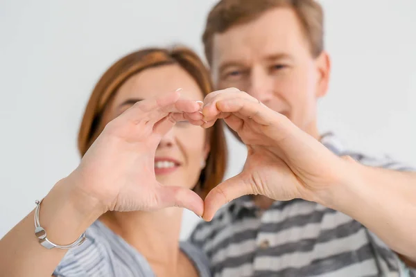 Beautiful couple holding hands in shape of heart, closeup — Stock Photo, Image