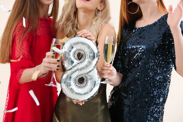 Beautiful young women with champagne and balloon in shape of figure 8. International Women's Day celebration — Stock Photo, Image