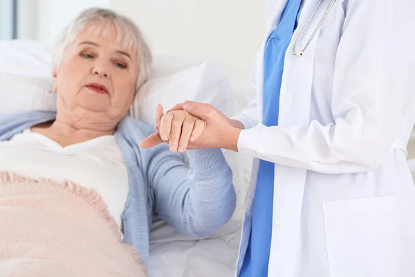 Female doctor with senior woman suffering from Parkinson syndrome in clinic — Stock Photo, Image