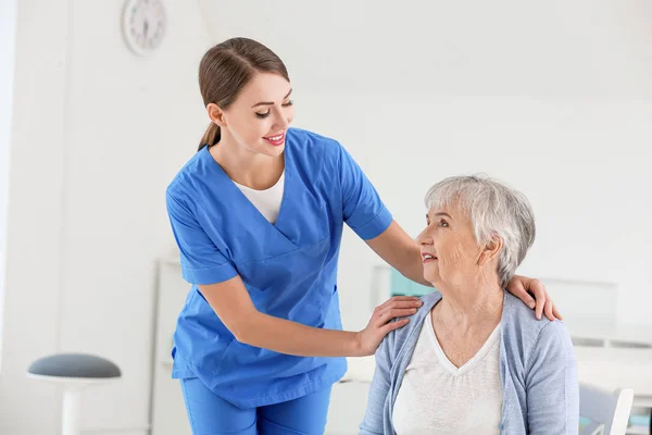 Medico femminile con donna anziana affetta da sindrome di Parkinson in clinica — Foto Stock