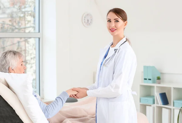 Female doctor with senior woman suffering from Parkinson syndrome in clinic — Stock Photo, Image