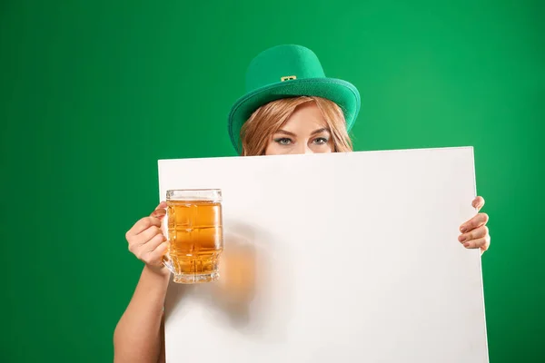 Jonge vrouw met lege poster en bier op kleur achtergrond. St. Patrick 's Day viering — Stockfoto