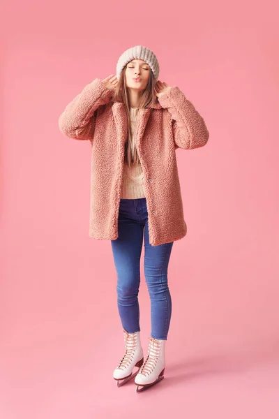 Mooie jonge vrouw op schaatsen tegen kleur achtergrond — Stockfoto