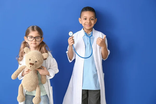 Niedliche kleine Ärzte auf farbigem Hintergrund — Stockfoto