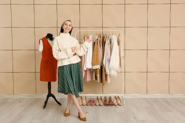 Female stylist near rack with modern clothes — 스톡 사진