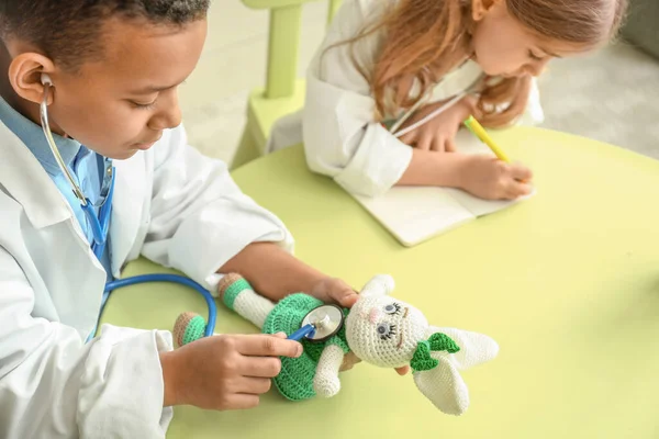 Cute little children dressed as doctors playing at home — Stock Photo, Image