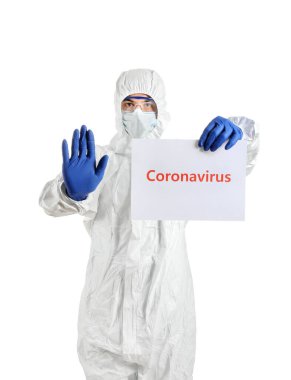 Koruyucu üniformalı bir laboratuvar çalışanı beyaz arka planda kağıt çarşaf tutuyor. Coronavirüs salgını kavramı