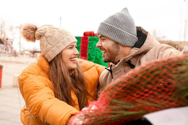 Happy young couple after buying Christmas tree at the market — Stock Photo, Image