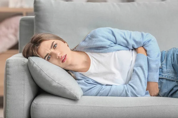 Young woman suffering from menstrual cramps at home — Stock Photo, Image