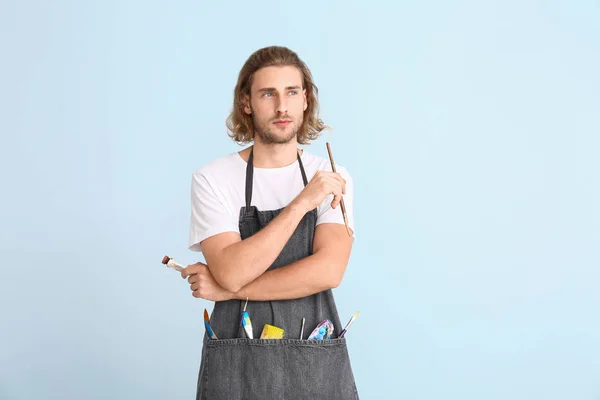 Portrait of young male artist on color background — Stock Photo, Image