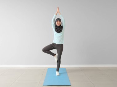 Sportif Müslüman kadın spor salonunda yoga yapıyor.