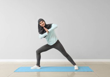 Sportif Müslüman kadın spor salonunda yoga yapıyor.