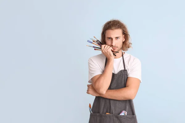 Portrait of young male artist on color background — Stock Photo, Image