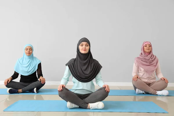 Sportliche muslimische Frauen praktizieren Yoga im Fitnessstudio — Stockfoto