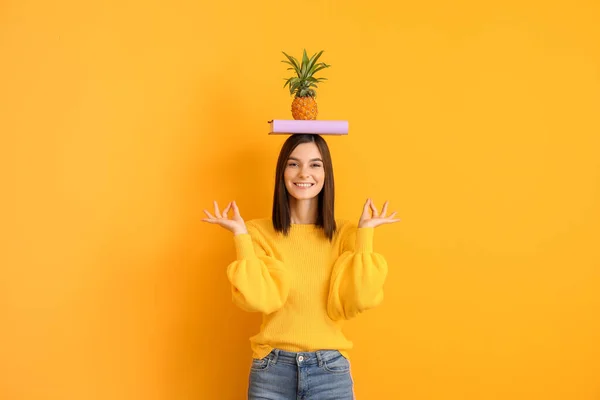 Bella giovane donna con libro e ananas su sfondo a colori — Foto Stock