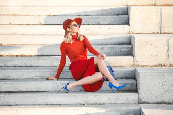 Porträt einer modischen jungen Frau, die auf Stufen im Freien sitzt — Stockfoto
