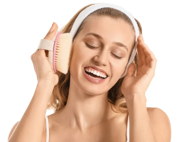 Beautiful young woman with massage brush on white background — Stock Photo, Image