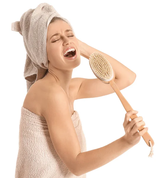 Mulher bonita se divertindo com escova de massagem no fundo branco — Fotografia de Stock